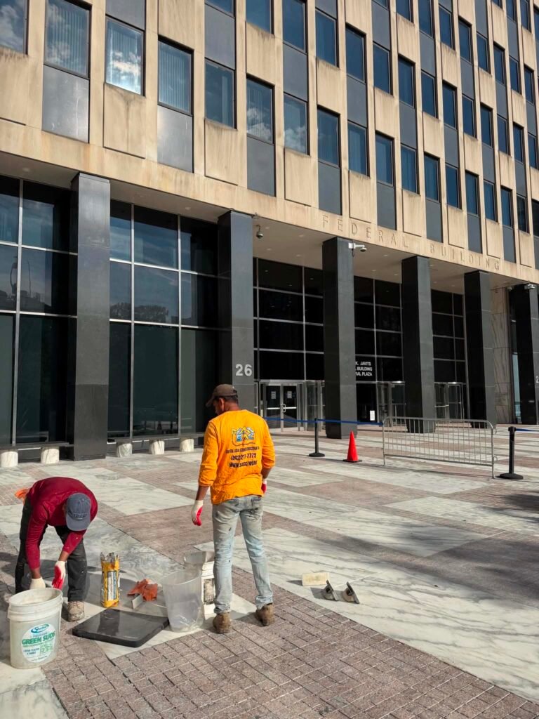 South Asia Construction Co. crew completing exterior grouting work at 26 Federal Plaza in New York City